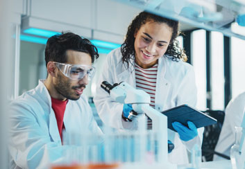 Medical experts looking into microscope