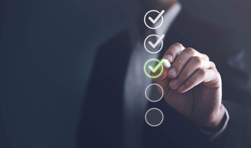 A businessman marks a green tick of approval