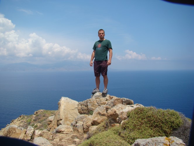 Man standing on a tip of Oia volcano in Greece