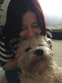 Dr. Denise Milovan hugging her dog, a Dandie Dinmont Terrier named Enki.