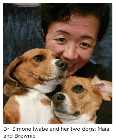 Dr. Simone Iwabe hugging her two beagles, Maia and Brownie